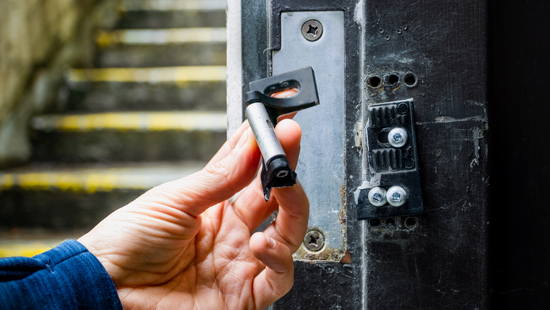 broken commercial door lock being held in hand