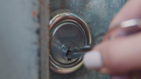 woman putting key into round door lock